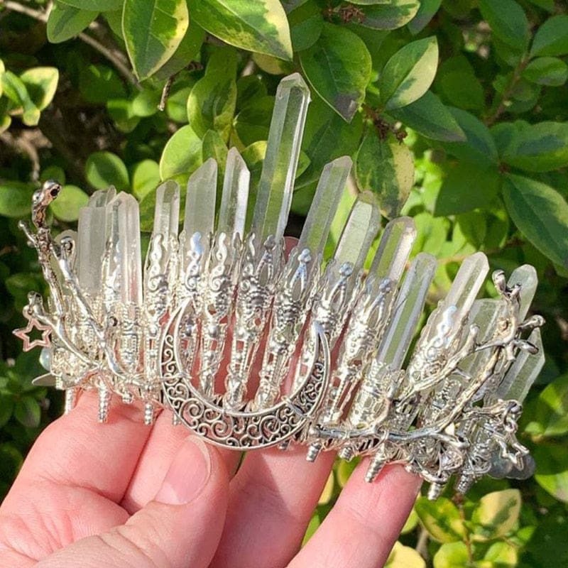 Handheld side angle of the clear quartz tiara with silver-tone wirework and tiny hanging stars.