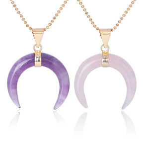 Purple amethyst and pale pink rose quartz crescent pendants displayed together, with downward-pointing tips and gold-tone chains.