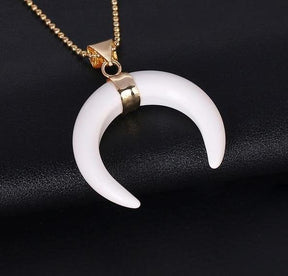 White Stone crescent pendant with a smooth pale surface, gold-tone centre setting and fine chain.