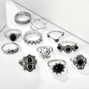 Eleven-piece silver-tone Namaste ring set with black accents displayed together on a white surface.