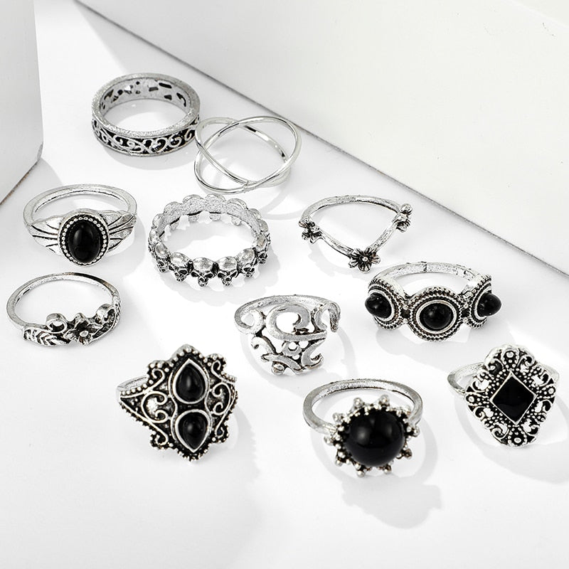 Eleven-piece silver-tone Namaste ring set with black accents displayed together on a white surface.