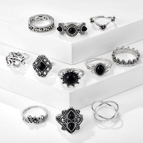 Eleven-piece silver-tone Namaste ring set with black accents shown in a second arrangement on stepped blocks.