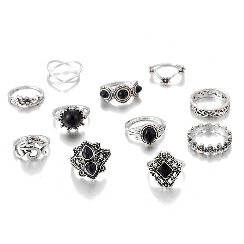 Eleven-piece silver-tone Namaste ring set with black accents arranged together on white with the Om motif and crossed band visible.