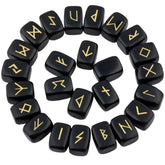 Obsidian rune stones arranged in a circle, with glossy black polished surfaces and gold-coloured characters. The set includes a blank stone.