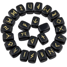 Obsidian rune stones arranged in a circle, with glossy black polished surfaces and gold-coloured characters. The set includes a blank stone.