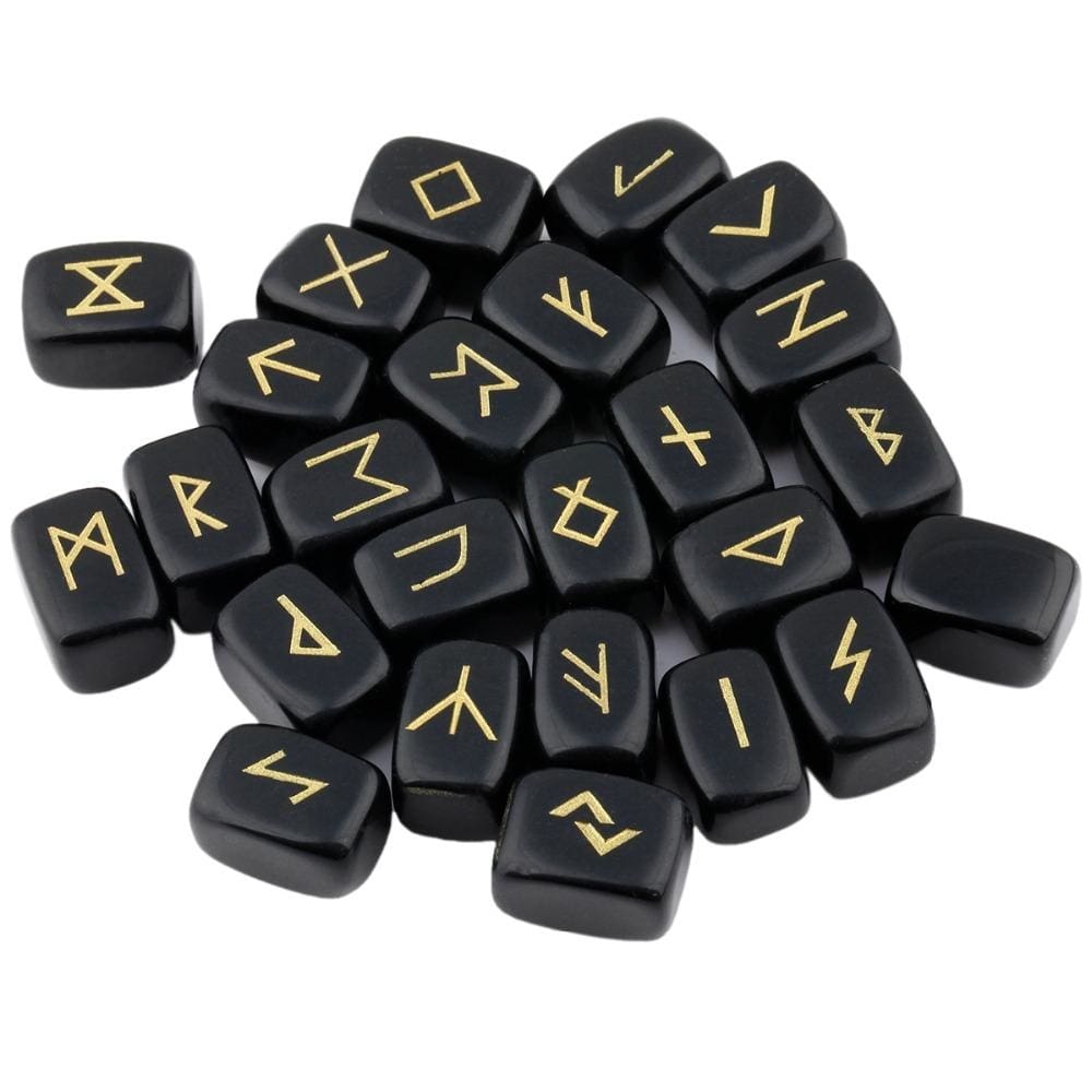 A loose pile of obsidian rune stones with glossy black surfaces, rounded edges and gold-coloured rune marks visible across the top.