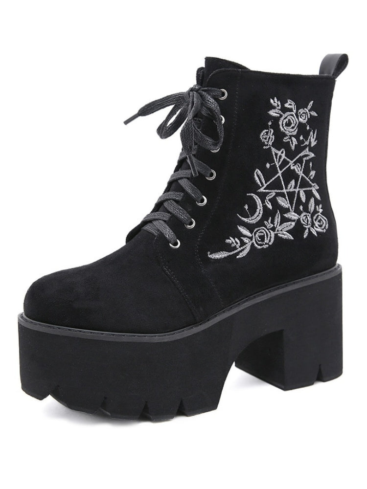 Black platform ankle boots with white pentagram, moon and rose embroidery shown as a single boot on white.