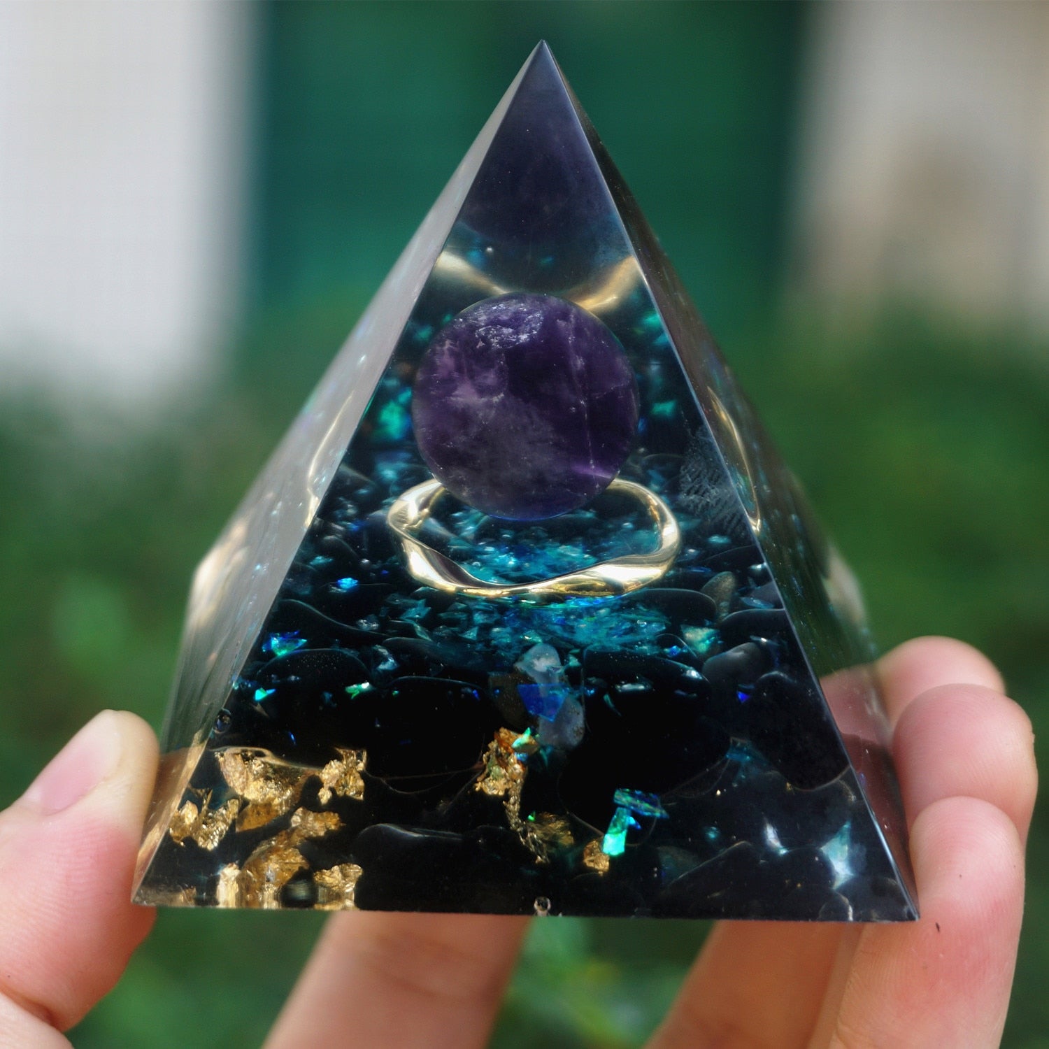 Additional view of Ocean amethyst orgone pyramid with a purple sphere, blue flakes and dark obsidian stones. The same shaded front composition shows the purple sphere above the dark base.