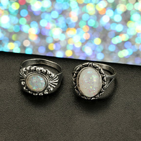 Eight-piece silver-tone opal-effect ring set with a close view of two decorated rings.