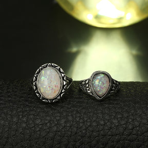 Eight-piece silver-tone opal-effect ring set with two rings shown in a close iridescent detail view.