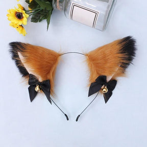 Fuzzy orange and black cat ear headband with pale inner ears, black ribbon bows, and gold-tone bells