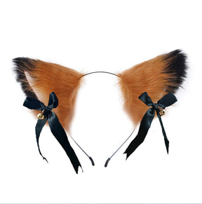 Fuzzy orange and black cat ear headband with pale inner ears, black ribbon bows, and gold-tone bells