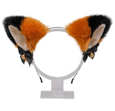 Fuzzy orange and black cat ear headband with pale inner ears, black ribbon bows, and gold-tone bells