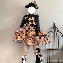 Orange tiered Halloween dress worn with a black long-sleeved underlayer, showing the bow-front bodice, dark trim and multiple layers of printed fabric.
