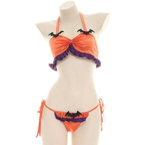Straight-on mannequin view of the orange Halloween halter top and matching bottoms, showing three black bat accents, purple ruffled edges and orange side ties.