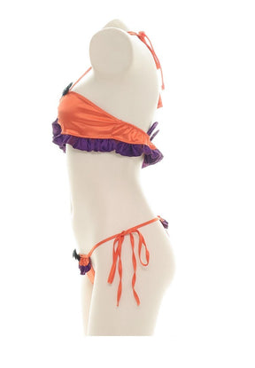 Side profile of the orange and purple lingerie set on a mannequin, showing the halter strap, ruffled band beneath the bust and long orange ties at the hip.