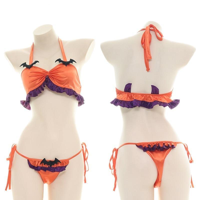 Front and rear mannequin views of an orange Halloween lingerie set with purple ruffles, black bat accents and tie-side bottoms. Two purple horn-shaped details rise from the back of the top.