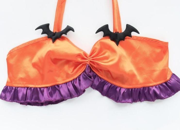 Orange Halloween halter top laid flat on white, showing two black bat accents, a gathered center and purple ruffles along the lower edge.