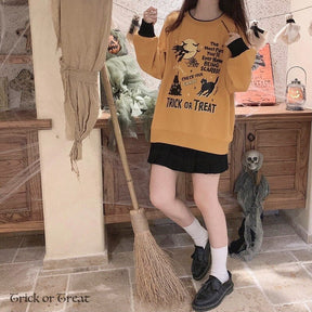Full mirror view of the orange Trick or Treat sweatshirt and black skirt, styled with white socks and black shoes in a Halloween-decorated room.