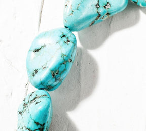 Another close angle of the oval-stone choker, showing the contrasting dark lines across the bright turquoise colour.