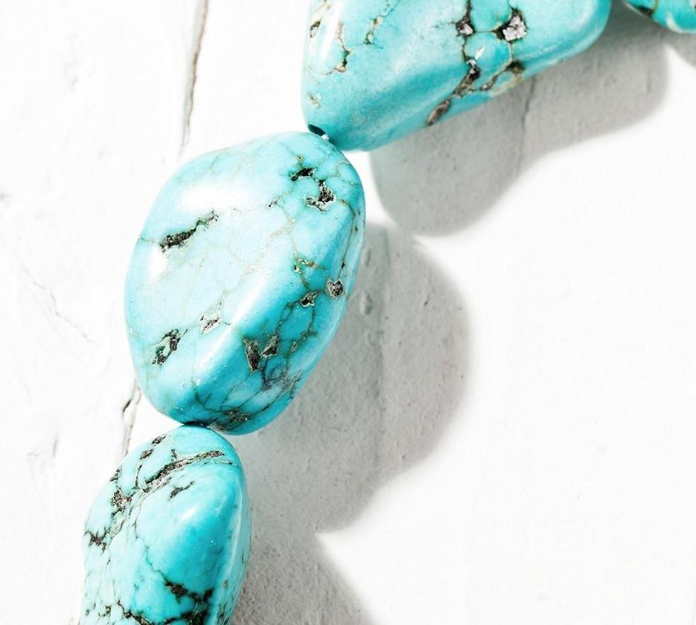 Another close angle of the oval-stone choker, showing the contrasting dark lines across the bright turquoise colour.
