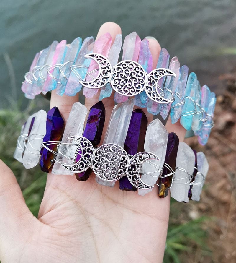 Two pale crystal crowns with triple moon centres, showing pastel rainbow beside purple-clear points.