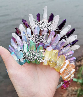 A group of pale triple moon crowns with purple, clear and pastel rainbow crystal points around silver-tone lunar emblems.