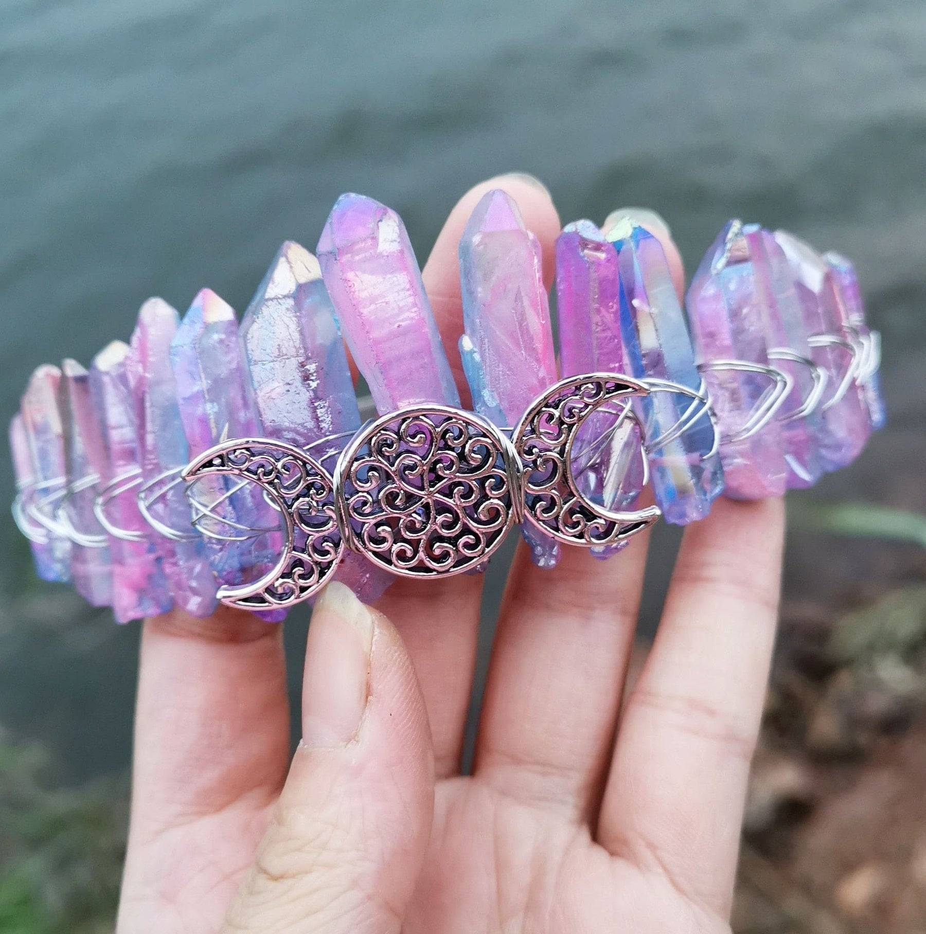 Pastel pink, blue and yellow points rise around the silver-tone triple moon emblem in this close view of the crystal crown.