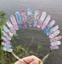 Front view of a pastel rainbow crystal point crown with a silver-tone triple moon emblem and wire-wrapped band.