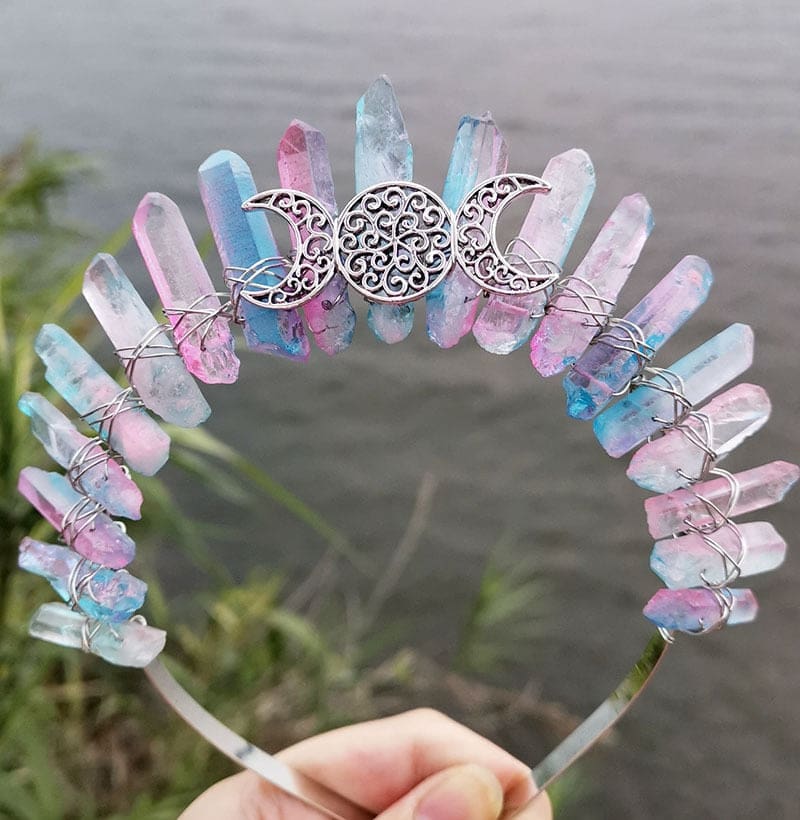 Front view of a pastel rainbow crystal point crown with a silver-tone triple moon emblem and wire-wrapped band.