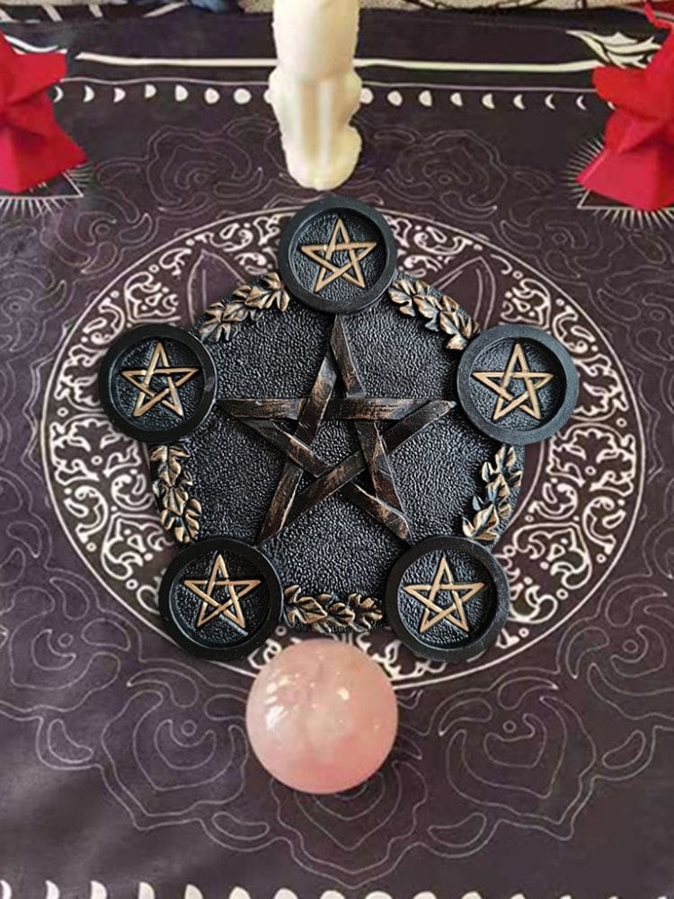 Overhead view of the black pentagram holder beside a pink crystal sphere, showing five star-marked platforms within a leafy circular border.