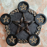 Black pentagram candle holder with bronze-tone leaf accents and five raised round platforms, each decorated with a small star.