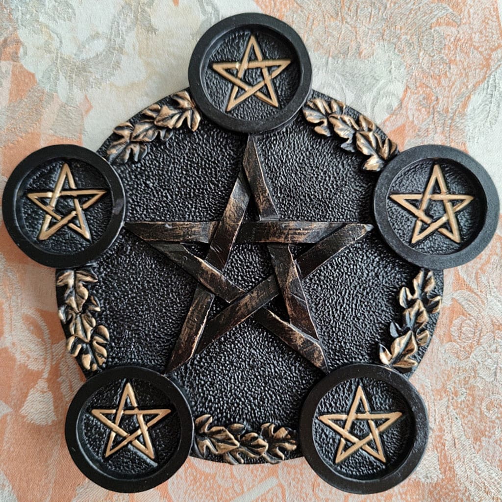 Closer angled view of the black pentagram holder, showing the leafy border and small stars within the five candle platforms.