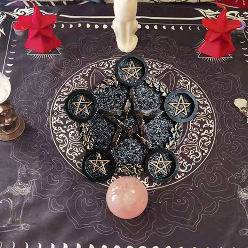 Wider altar arrangement with the black pentagram holder on a dark patterned cloth near a crystal sphere and decorative accessories.