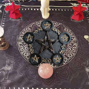Wider altar arrangement with the black pentagram holder on a dark patterned cloth near a crystal sphere and decorative accessories.