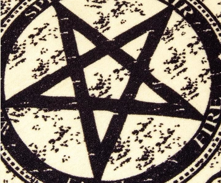 Close-up of the rug's large five-pointed star and surrounding distressed circular artwork.
