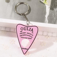 Solid pink planchette keychain with black lettering and a black border, attached to a short silver-tone chain and ring above a circular cutout.