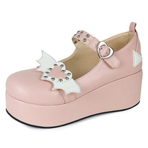 Pink Winged Heart platform Mary Jane with white wing details and silver-tone studs, displayed with the heart buckle facing the camera.