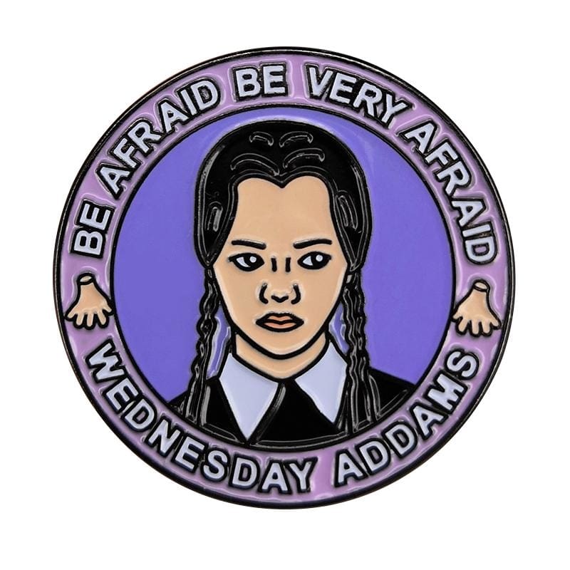 Round purple enamel pin with a black-braided portrait, white collar and Be Afraid, Be Very Afraid lettering around the top.