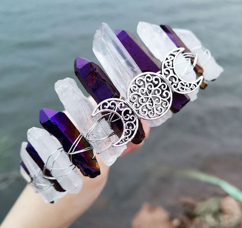 Purple and clear points frame the silver-tone triple moon emblem, with the crown tilted to show its curved wire-wrapped band.