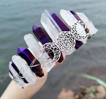 Angled view of a purple clear crystal point crown with a silver-tone triple moon emblem and wire-wrapped band.