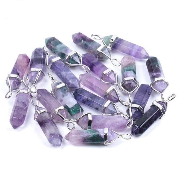 Purple fluorite pendants with faceted sides and pointed tips, arranged together with their silver-tone settings.