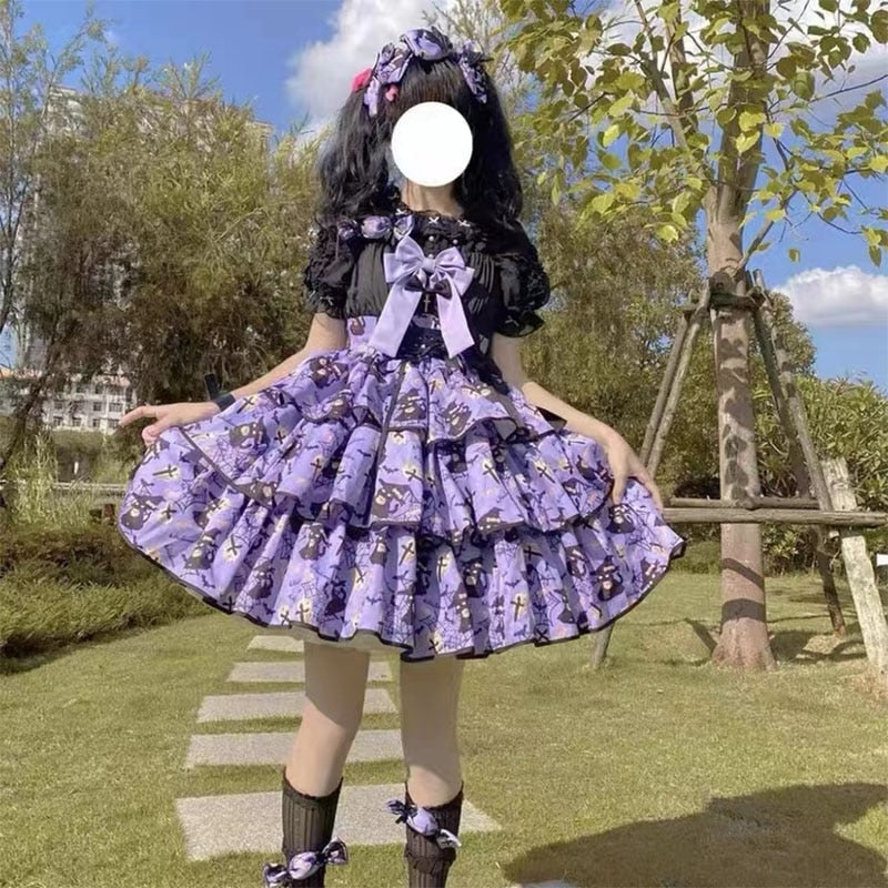 Purple tiered Halloween dress worn outdoors with a black underblouse, showing the large lavender bow and black edging around the full printed skirt.