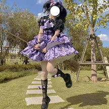 Full outdoor view of the purple tiered Halloween dress with a black underblouse and dark socks, with one leg lifted to show the platform shoe.