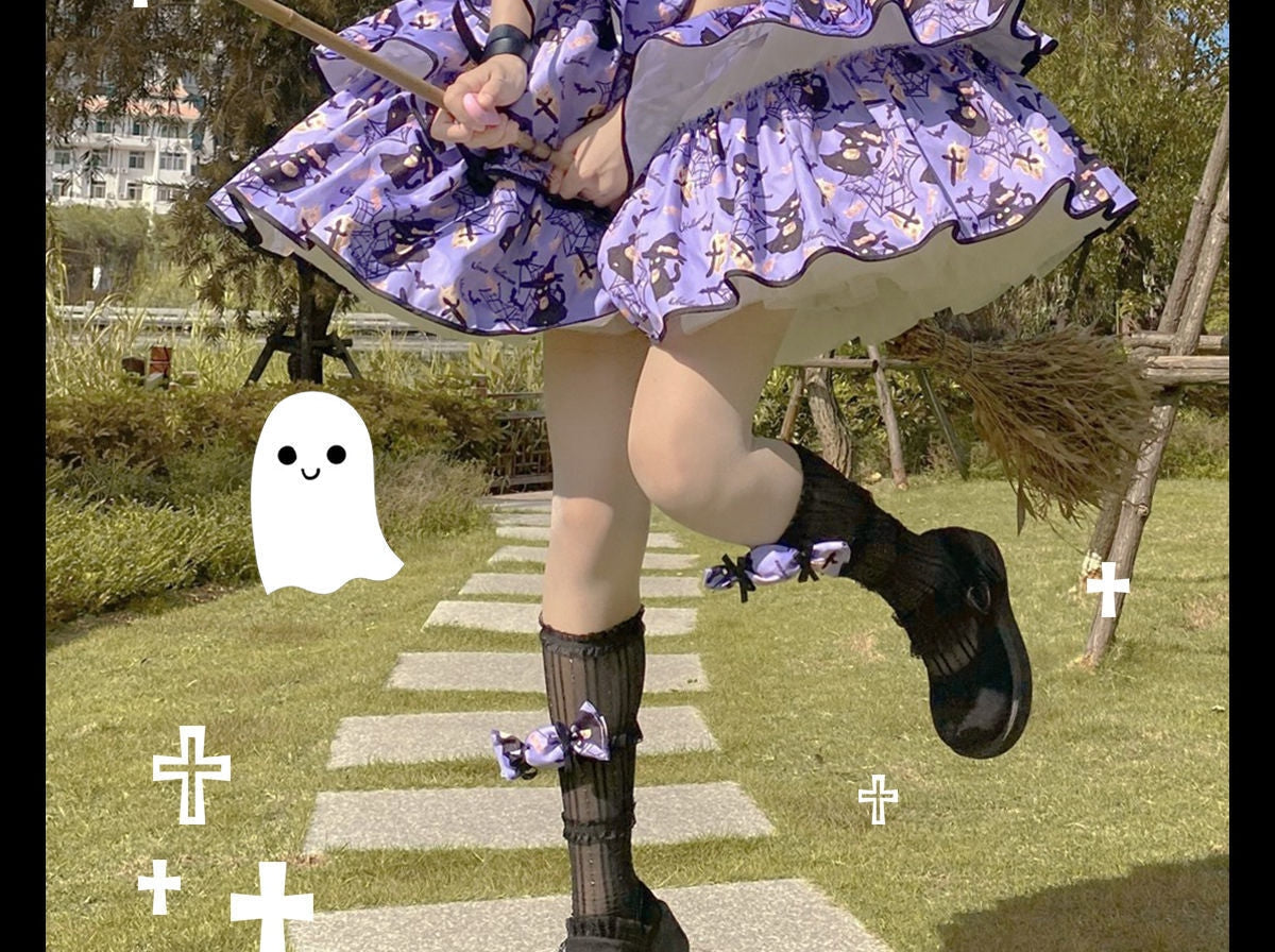 Detail of the purple Halloween dress skirt and hem outdoors, with black-edged printed tiers above dark socks and shoes.