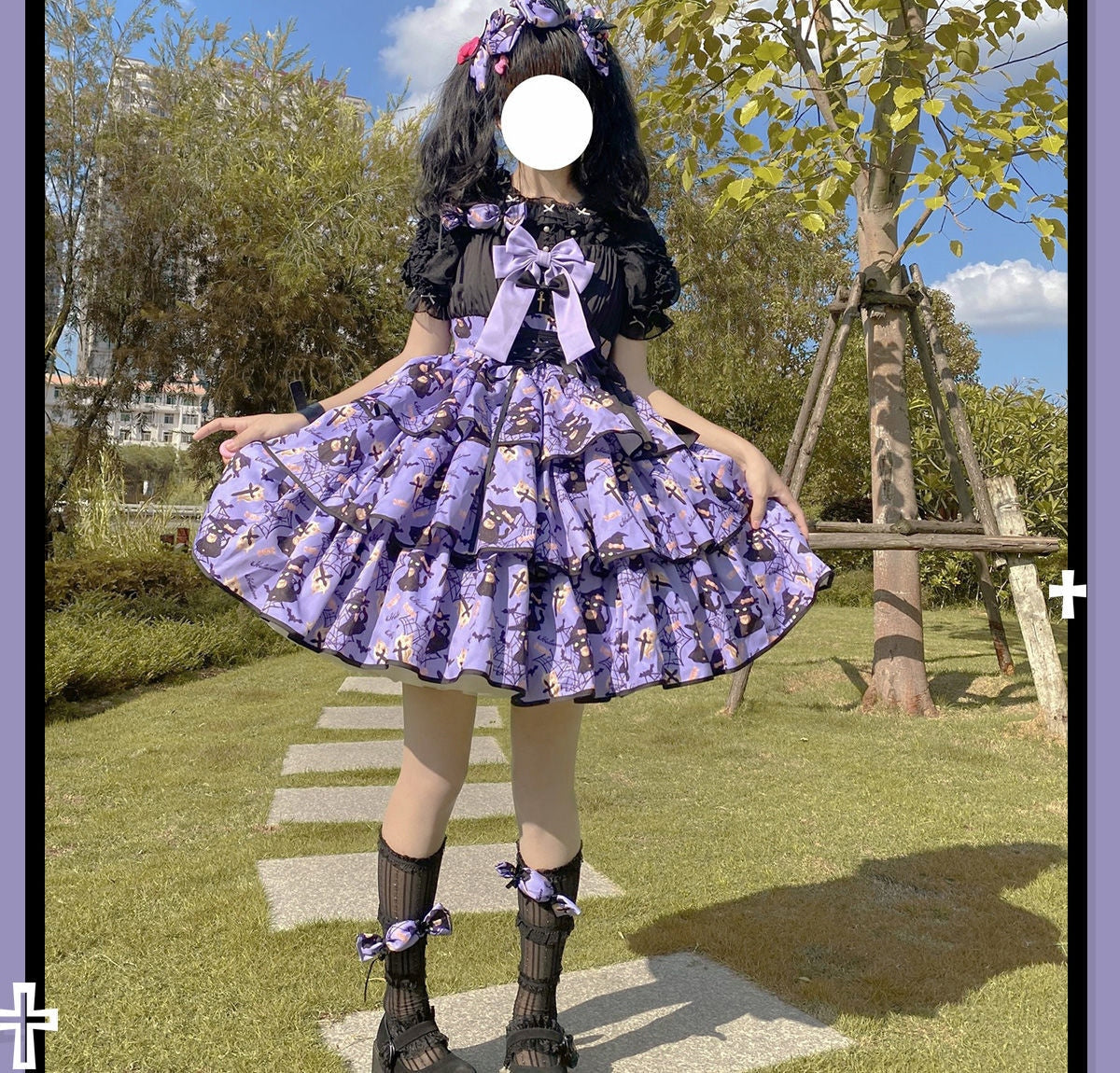 Front outdoor view of the purple Haunted Halloween dress, showing the large bow, ribbon-laced bodice and tiered skirt beneath a black underblouse.