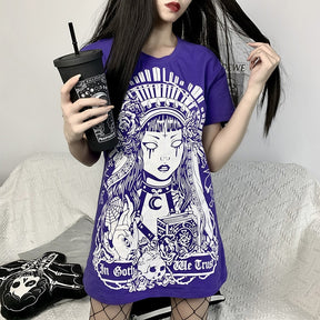 In Goth We Trust graphic T-shirt in Purple, worn in a wider seated view.