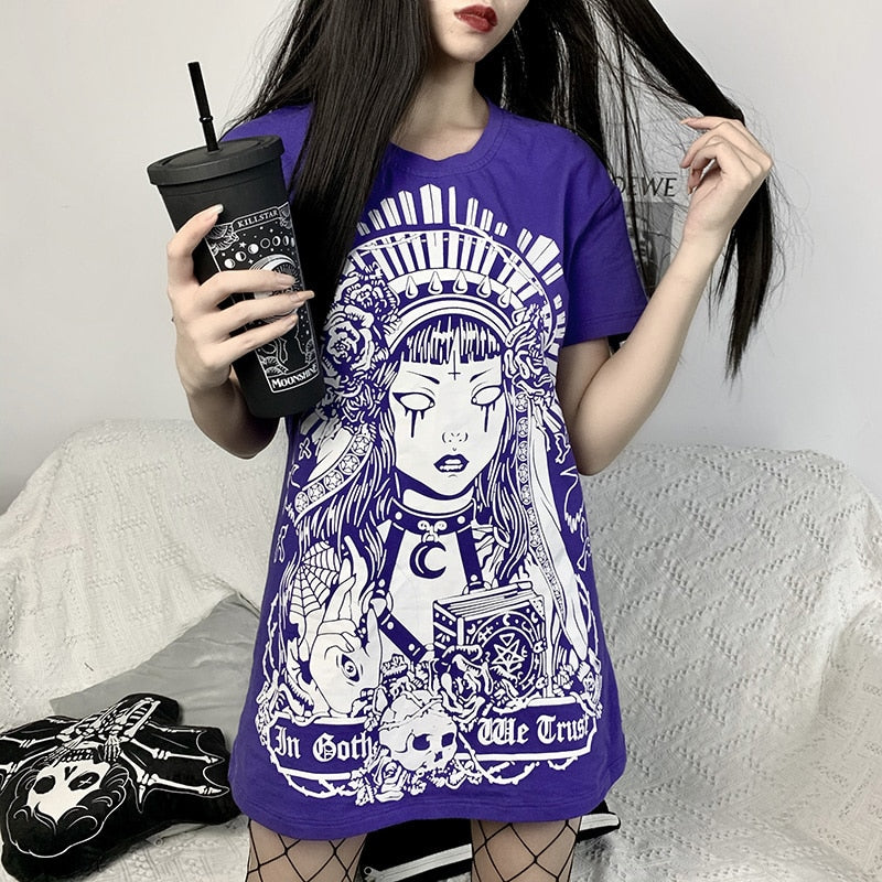 In Goth We Trust graphic T-shirt in Purple, worn in a wider seated view.