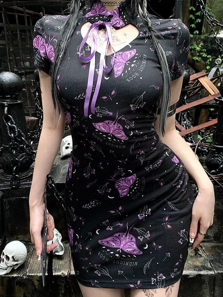 Black cheongsam-inspired dress seen from the front, with purple moth artwork across the fitted waist and short sleeves beside stone steps.
