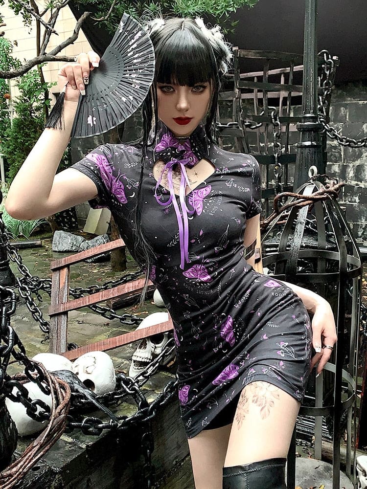 Angled view of the purple moth dress with a folding fan raised beside the head, showing its short fitted shape and long collar ribbon.